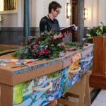 A woman reads something during a funeral service.