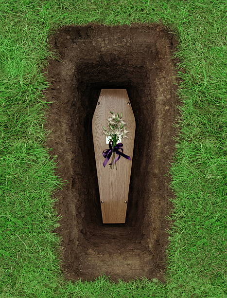 A basic wood coffin in a grave.