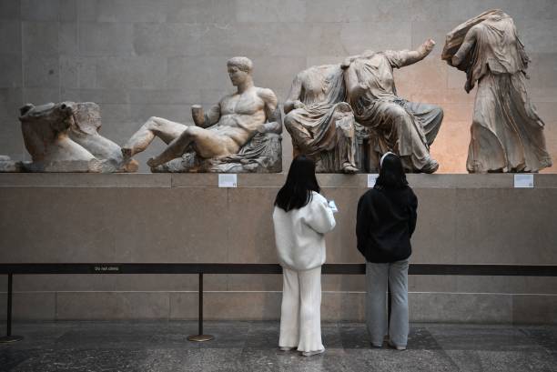 Museum-goers regard the Elgin Marbles.